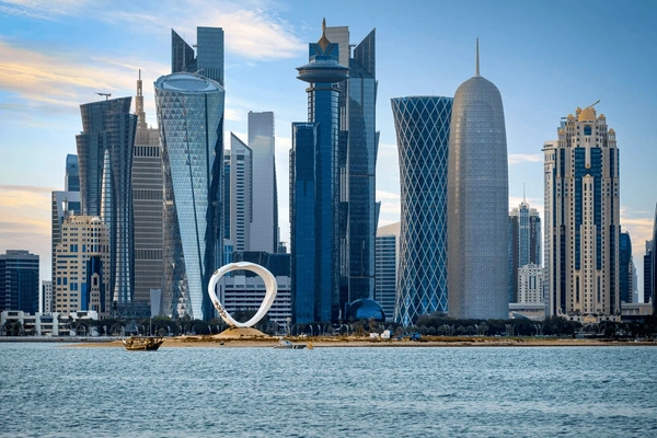 Modern Doha skyline blended with business professionals working together, symbolizing Conduire Services WLL bridging corporate, financial, and regulatory gaps in Qatar and beyond.